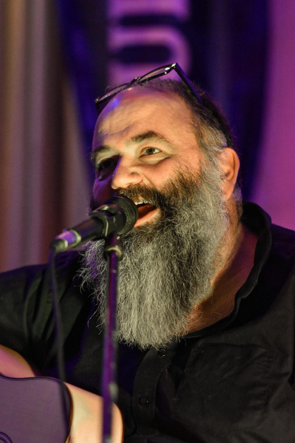 Micha Krämer singt lächelnd ins mikrofon